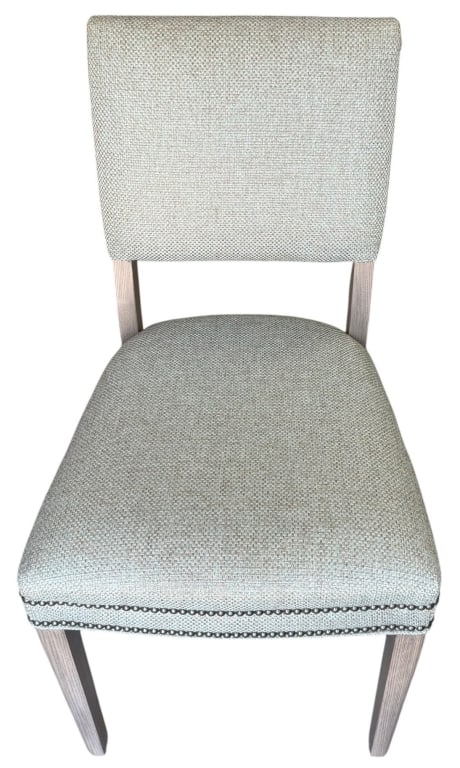 UPHOLSTERED SIDE CHAIR WITH NAILHEAD TRIM 37" H: Contemporary side chair featuring a fully upholstered seat and back in textured neutral fabric. The chair is accented with nailhead trim along the seat rail and back edges and raised on a light wood f