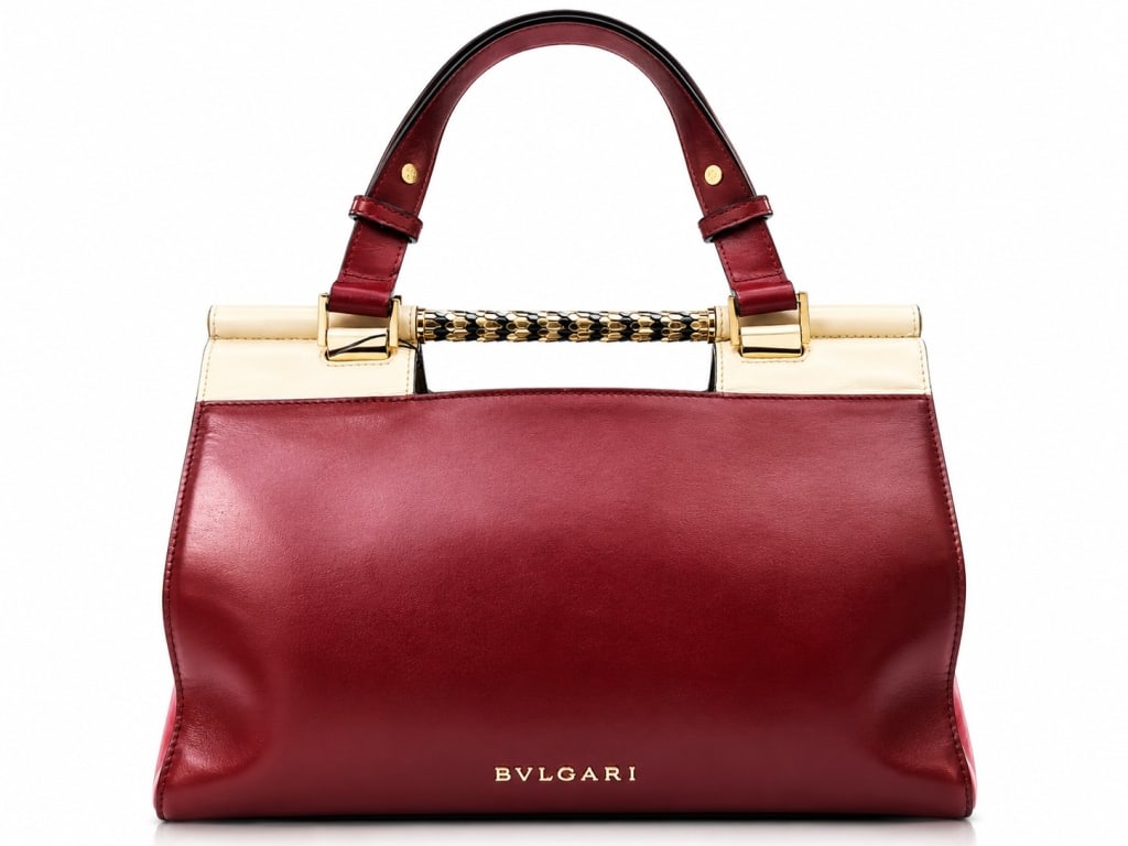 BVLGARI SERPENTI SCAGLIE HANDBAG 12": Elegant, distinctive, and regal, this Bvlgari Serpenti Scaglie handbag showcases the Italian luxury house's celebrated serpent-inspired design aesthetic. Crafted in rich burgundy and blush leather wit