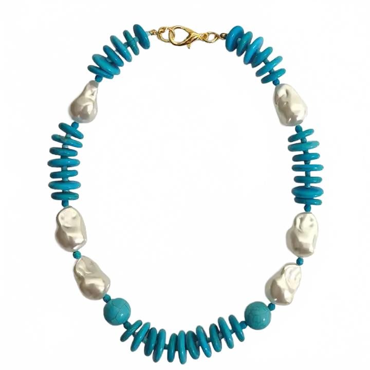 Turquoise and Baroque Pearl Necklace: Bold necklace featuring vibrant turquoise disc beads paired with large, irregular baroque freshwater pearls. Completed with a gold-tone lobster clasp, this statement piece combines bohemian style and 