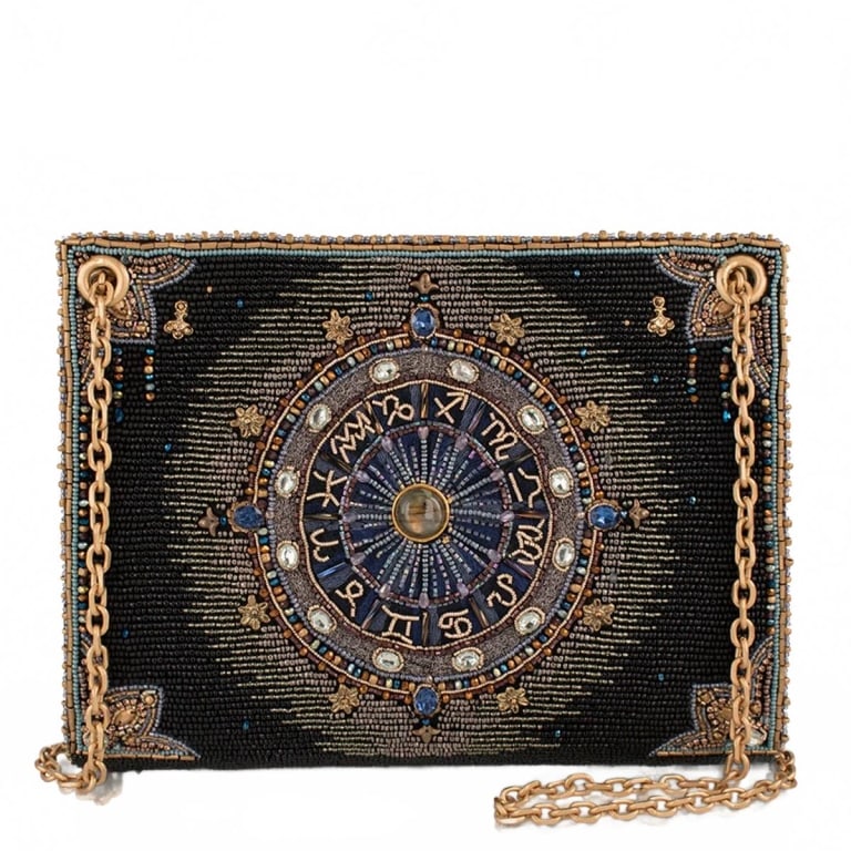 NEW MARY FRANCES COSMIC ENERGY BAG: The Cosmic Energy crossbody is a hand-beaded masterpiece featuring an intricate zodiac wheel at its center, surrounded by celestial detailing in deep midnight black, gold, and jewel tones that feel li