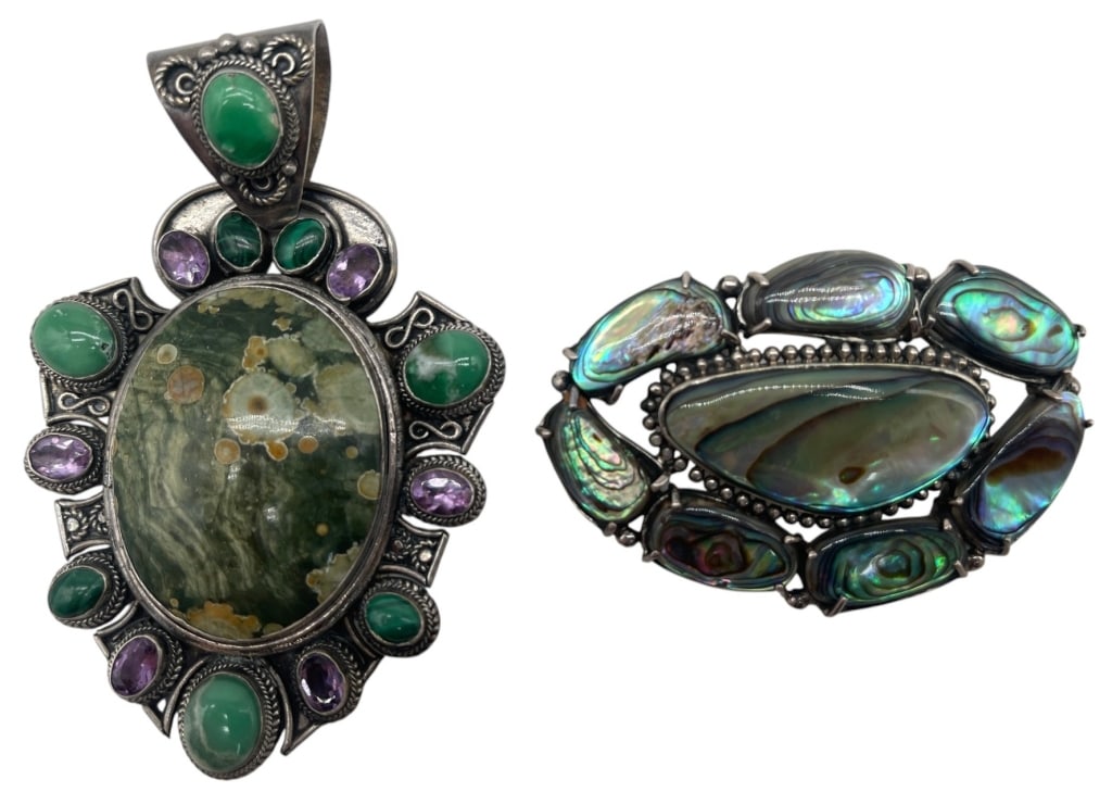 LOT OF 2 STERLING SILVER JEWELRY PCS 63.7G 4in: Lot of two sterling silver jewelry pieces including a large statement pendant and an ornate brooch. The pendant features a polished oval cabochon stone surrounded by green cabochons and faceted purple