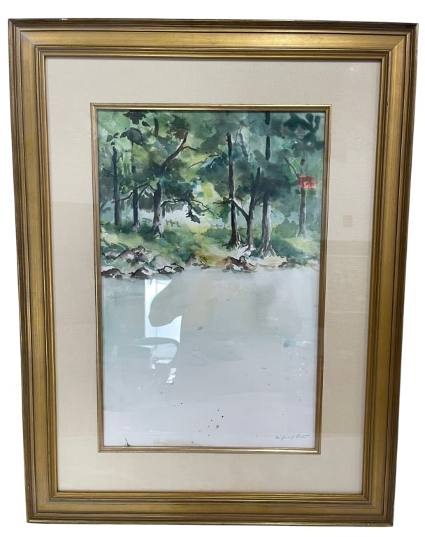 FRAMED WATERCOLOR WOODLAND LANDSCAPE 31": Delicate watercolor landscape depicting a tranquil wooded scene with trees, rocky shoreline, and soft reflections along the water's edge. Executed in loose, impressionistic brushwork with layered gree