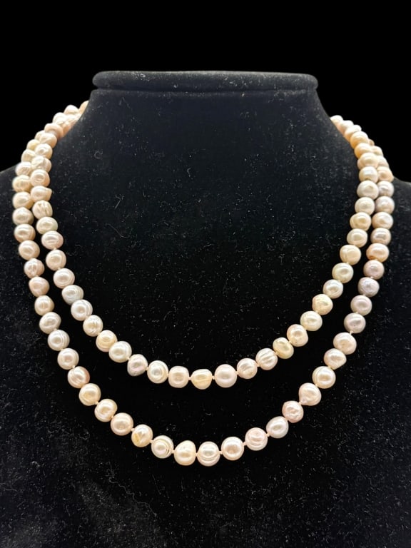 ELEGANT CULTURED PEARL NECKLACE 18": The necklace showcases softly iridescent cultured pearls with natural variations in shape and color, gathered into an eye-catching central cluster with a dangling looped drop. Its versatile design off