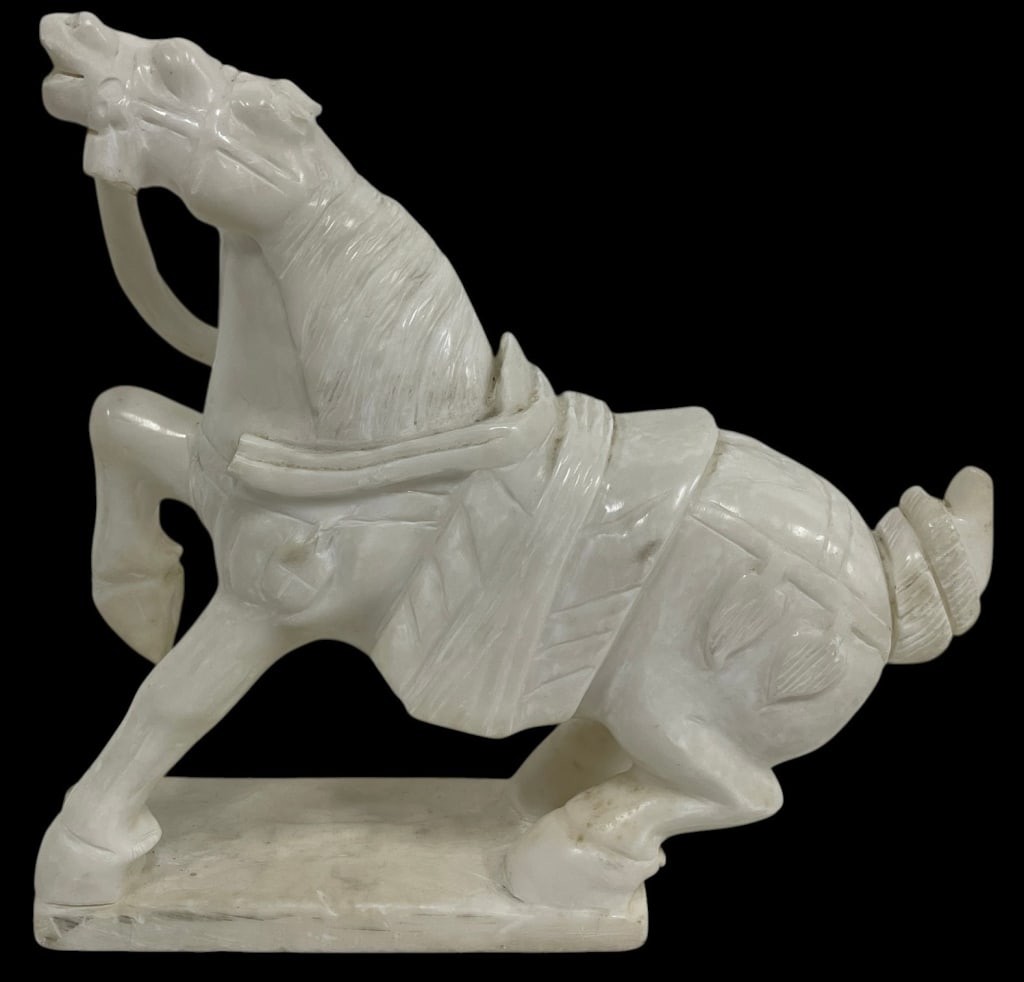 CARVED WHITE STONE TANG STYLE HORSE FIGURE 14": Decorative carved white stone horse sculpture depicting a spirited horse in motion with stylized tack and saddle details. The piece features hand-carved accents throughout the mane, body, and harness,