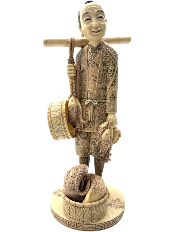OKIMONO STYLE FISHERMAN FIGURE 13": Finely detailed Japanese-style okimono depicting a smiling fisherman carrying a shoulder pole with hanging fish and baskets. The figure is richly decorated with intricate engraved kimono patterns, flo
