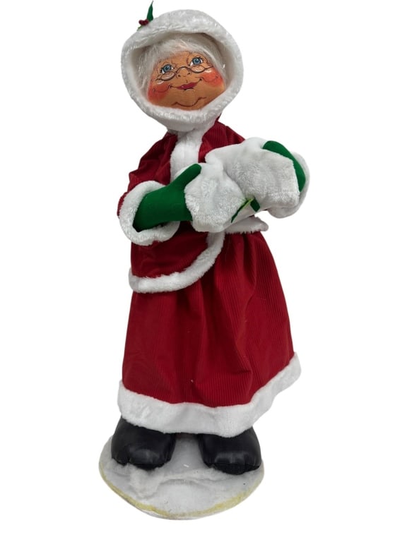 ANNALEE HOLIDAY FIGURINE WITH RED COAT: Annalee figurine featuring a holiday theme, dressed in a red and white coat. Figure depicts a smiling character with glasses and holly detail on the hood. Shipping Available at www.DeJaVuAuctionShippi