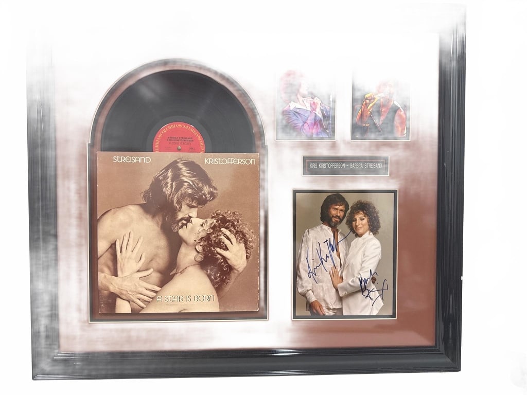SIGNED STREISAND KRISTOFFERSON ALBUM DISPLAY: Framed display featuring a vinyl record and cover of "A Star is Born" signed by Barbra Streisand and Kris Kristofferson. Includes album art, two live performance photos, and a signed promo photo. Fram