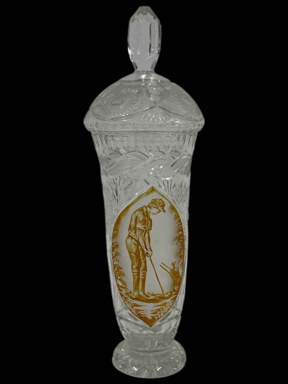 CUT GLASS LIDDED JAR WITH GOLF SCENE DECORATION: CUT GLASS LIDDED JAR WITH GOLF SCENE DECORATION 24" X 7" D APPROX-Elegant cut glass lidded jar featuring detailed wheel-cut patterns and a central oval reserve decorated with a golfer motif in warm am