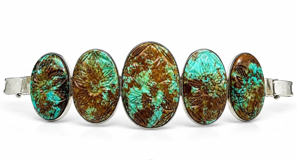 OVERSIZED STONE CARVED TURQUOISE BRACELET 7": Handcrafted sterling silver bracelet featuring five oval carved turquoise gemstone panels, each decorated with an intricately carved floral motif and set in smooth sterling bezels. The bracelet is mar