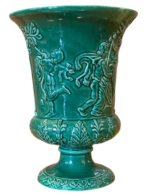 GREEN MAJOLICA STYLE RELIEF URN 9": Decorative green glazed majolica style pedestal urn featuring a flared rim, raised classical figural relief scenes, molded acanthus leaf borders, and a glossy jewel-tone glaze. | DIMENSIONS: 4" W X 9"