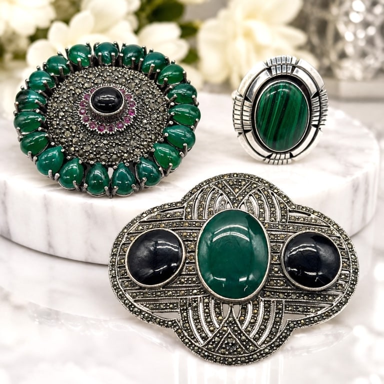 STERLING SILVER BROOCH & RING LOT 2.25IN: Collection of three sterling silver jewelry pieces including two decorative brooches and one statement ring. The lot features an Art Deco-inspired marcasite brooch set with a central green cabochon an