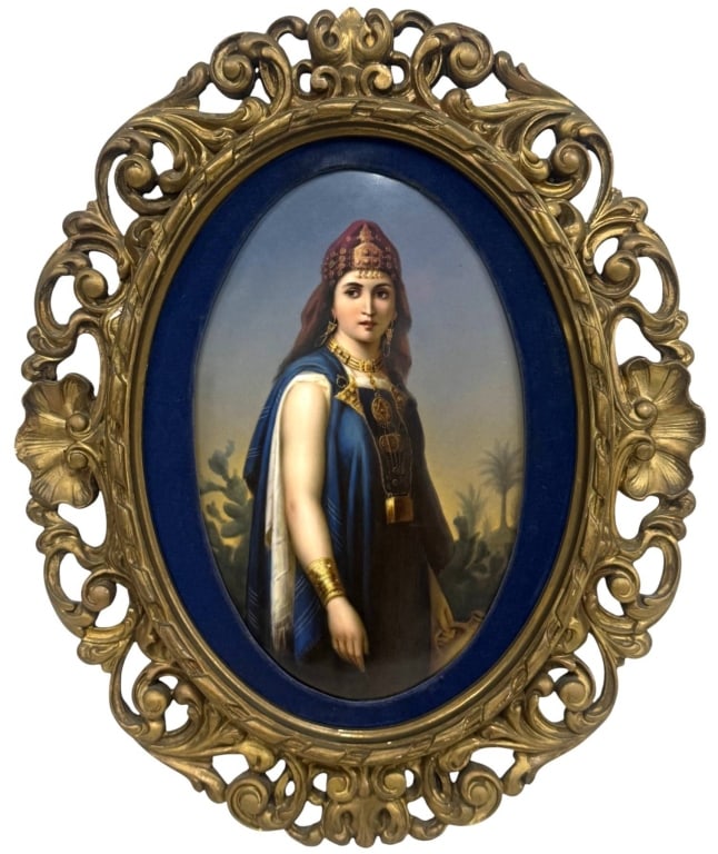 19TH C. GERMAN PORCELAIN PORTRAIT PLAQUE 14" x 9": Antique hand-painted German oval porcelain plaque depicting an orientalist woman in traditional attire with jeweled adornments and rich blue garments. Mounted in an ornate openwork gilt carved wood fr