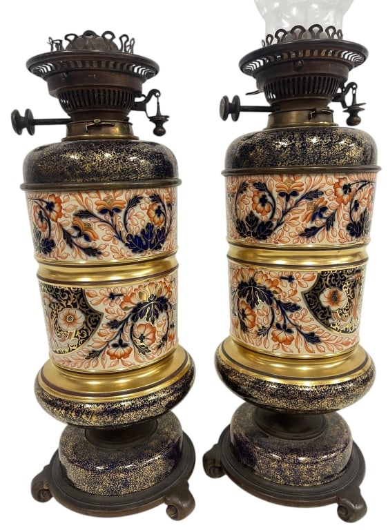PAIR OF IMARI STYLE KEROSENE LAMPS 25": This decorative pair of vintage kerosene lamps features richly detailed Imari-style ceramic fonts decorated with traditional cobalt blue, iron red, and gilt floral motifs accented by bronzed metal bur