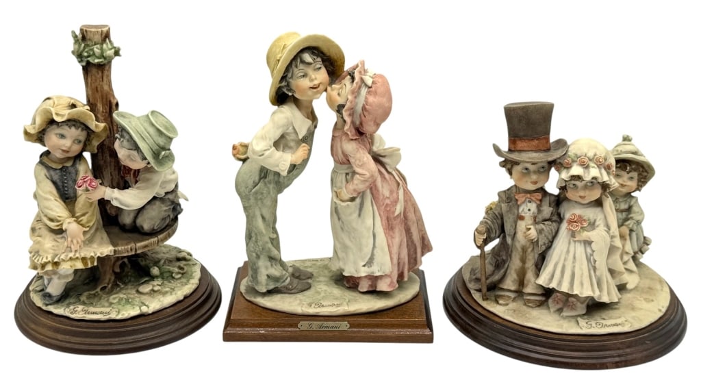 LOT OF THREE GIUSEPPE ARMANI FIGURINES: Collection of three Giuseppe Armani porcelain figurines, each mounted on a fitted wood display base with engraved nameplates. The grouping includes a romantic couple sharing a kiss, two children seate