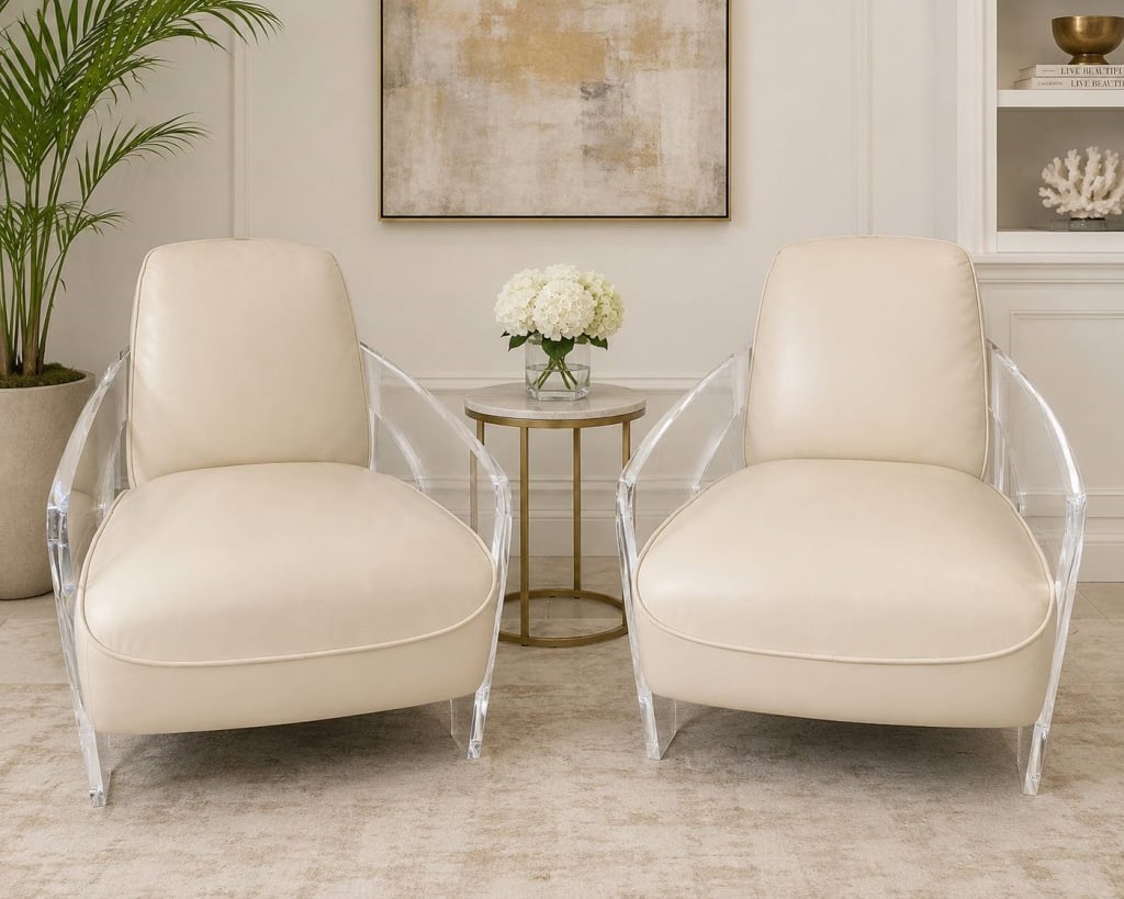 PAIR OF LUCITE & LEATHER LOUNGE CHAIRS 32": This elegant pair of contemporary lounge chairs features sculptural clear lucite frames paired with ivory leather upholstered seats and backs. The transparent acrylic arms and legs create a floating a
