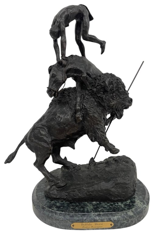BUFFALO HORSE BRONZE AFTER REMINGTON 15": This dramatic bronze-finish sculpture is modeled after Frederic Remington's iconic Buffalo Horse composition, depicting a Native American rider balancing atop a horse mounted on a charging buffalo. Ri