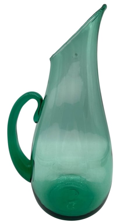 ART GLASS EMERALD GREEN PITCHER 14": Elegant hand-blown art glass pitcher featuring a graceful elongated silhouette in a vibrant emerald green transparent glass. The sculptural form includes a tall flared pouring spout, rounded body, and