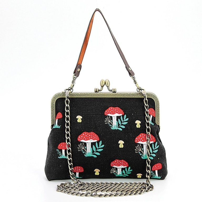 BLACK MUSHROOM KISSKOCK BAG: Mushrooms Kisslock Frame Bag | | Embrace whimsical charm with the Mushrooms Kisslock Bag, a delightful accessory that celebrates the enchanting beauty of mushrooms. This bag blends nature-inspired des
