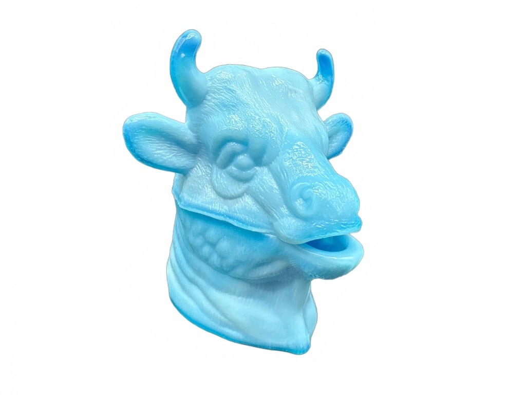 Blue Glass Cow Head Trinket Box: Blue glass trinket box shaped as a cow's head with a removable lid. Features detailed facial features and horns. Stands approximately 4 inches tall. No maker's mark visible. Good condition without app