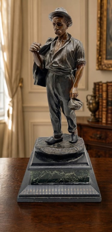 PICCIOLI RETOUR AU FOYER BRONZE FIGURE 17": Patinated bronze sculpture titled Retour au Foyer, depicting a weary laborer returning home while carrying a sack and jacket. The naturalistically modeled figure features contrasting brown and dark pa
