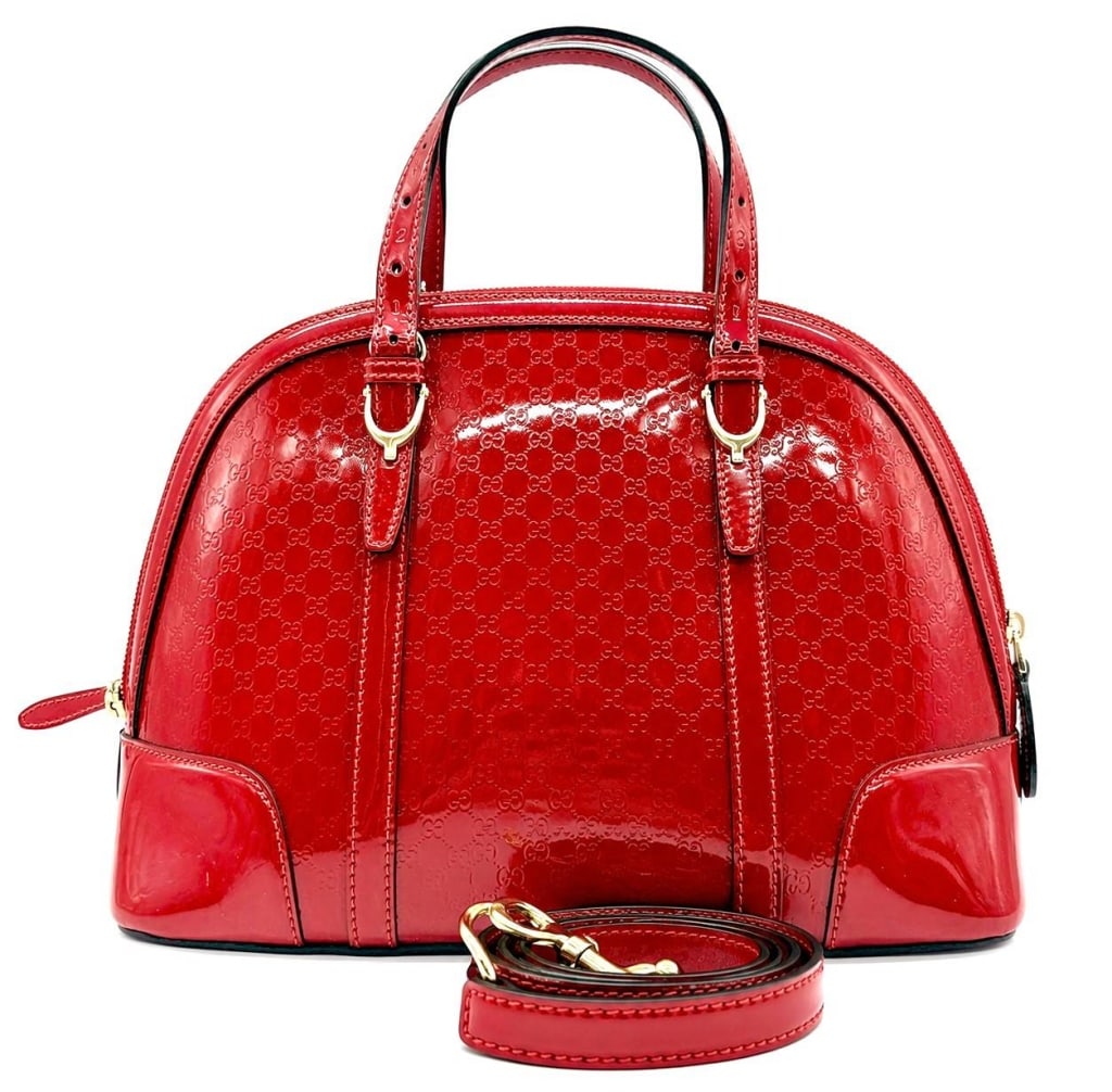 GUCCI MICROGUCCISSIMA RED PATENT LEATHER DOME BAG: This Gucci dome handbag is crafted in red Microguccissima embossed patent leather with gold-tone hardware and dual rolled leather handles. The structured zip-top silhouette features the iconic interlo