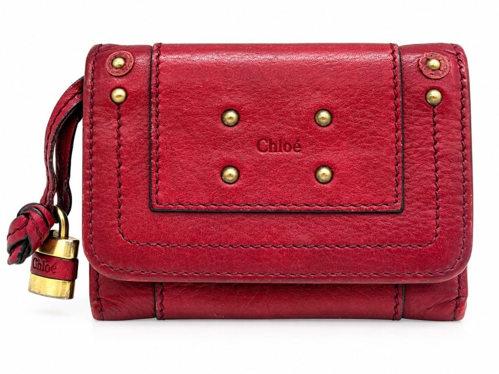 CHLOE PADDINGTON RED LEATHER KEY WALLET 4": This Chloé Paddington key wallet is crafted in rich red leather with the collection's signature antiqued brass-tone hardware, decorative rivet detailing, and iconic miniature padlock charm. The compa