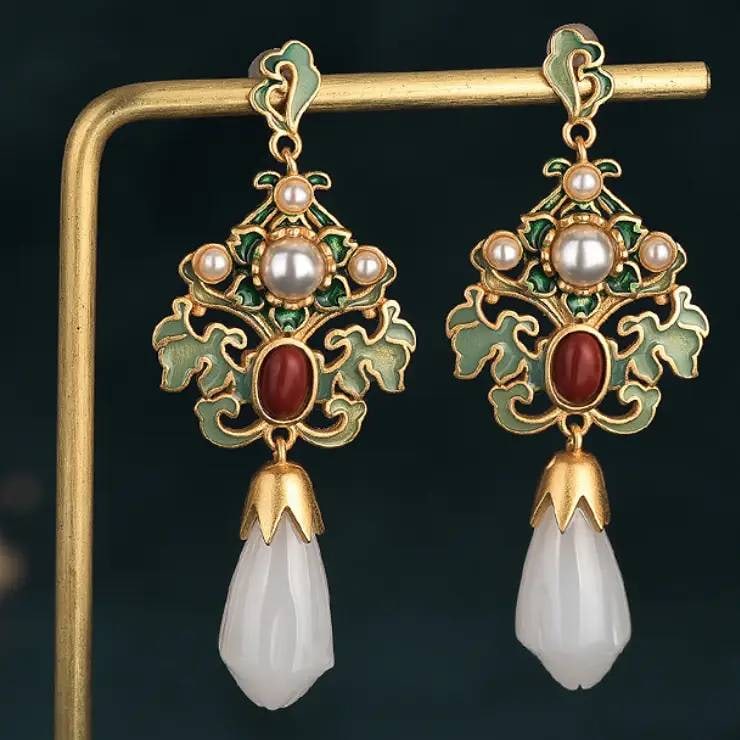 Luxury 24K GP Earrings with Jade and Pearl: Luxury earrings featuring green enamel detailing, pearls, red stones, and white jade drops. 24K GP Gold floral motif with 52mm length. Intricate craftsmanship blends enamel and jade elements.