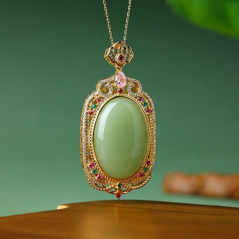Cinderella's Jade 24K GP Pendant Necklace: This necklace features Cinderella's jade centerpiece set in an ornate 24K GP gold frame with additional colored gemstones. The detailed openwork back and chain enhance the elegant presentation. Includ
