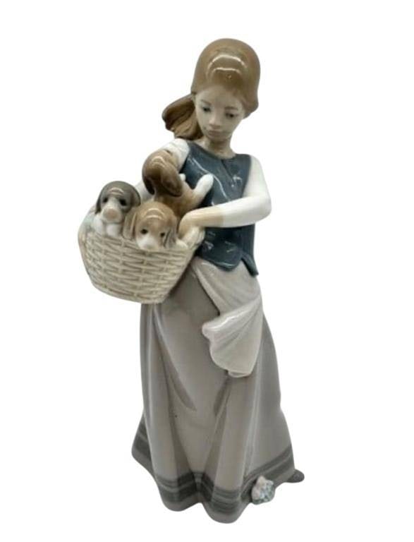 LLADRO GIRL W BASKET PUPPIES FIGURINE W BOX: -Elegant retired Lladró porcelain figurine #1311 issued 1977, depicting a young girl tenderly carrying a woven basket filled with playful puppies, rendered in signature glossy finish with soft pastel