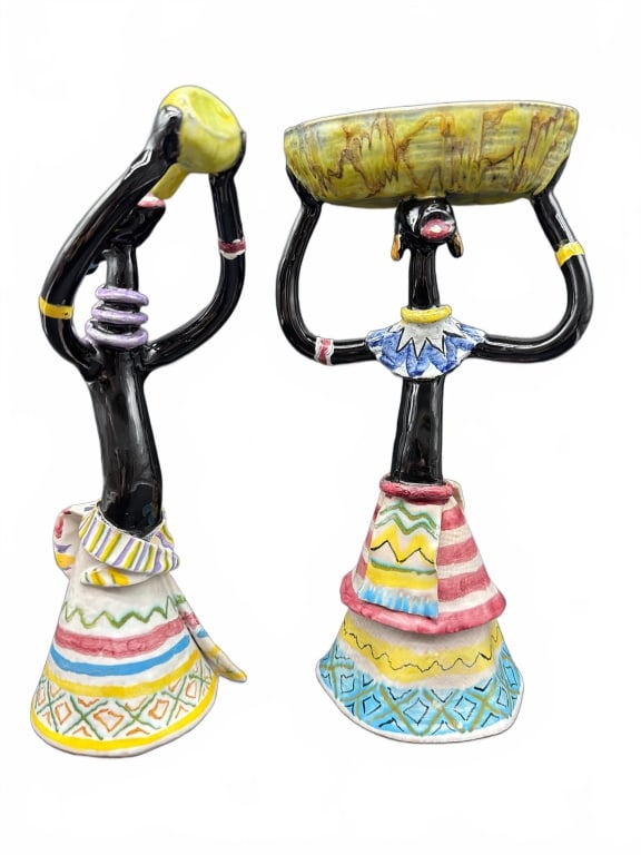 Colorful Ceramic African Figurines: Two hand-painted ceramic figurines depicting women in traditional dress. Each features black glazed bodies, one with a water jug and the other with a basket, standing approximately 8-9 inches tall.