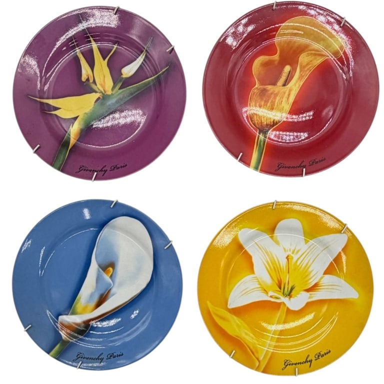 GIVENCHY PARIS FLORAL PLATES 10": Elegant set of four Givenchy Paris decorative porcelain plates featuring striking oversized floral designs in vibrant jewel tones of purple, red, blue, and golden yellow. Each plate showcases a differ