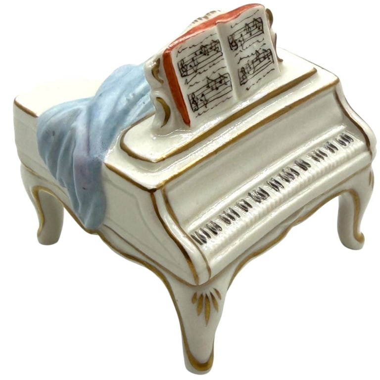 VOLKSTEDT GERMAN PORCELAIN GRAND PIANO 4": This antique German porcelain miniature depicts an elegant grand piano with an open music score resting on the stand and a draped blue cloth cascading across the instrument. Executed in a Rococo Reviv