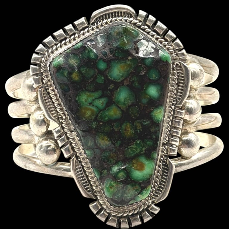 STERLING TURQUOISE CUFF BRACELET 2.5": Handcrafted sterling silver cuff bracelet featuring a striking freeform green turquoise cabochon with dramatic black matrix. The substantial stone is bezel set within an intricately detailed hand-fabr