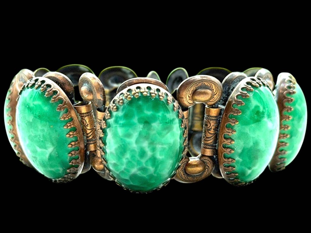 VINTAGE GREEN CABACHON LINK BRACELET 7.5": Vintage link bracelet featuring eight luminous oval green cabochons displaying an attractive mottled matrix pattern, each securely bezel set within ornate antiqued metal settings. Decorative engraved 