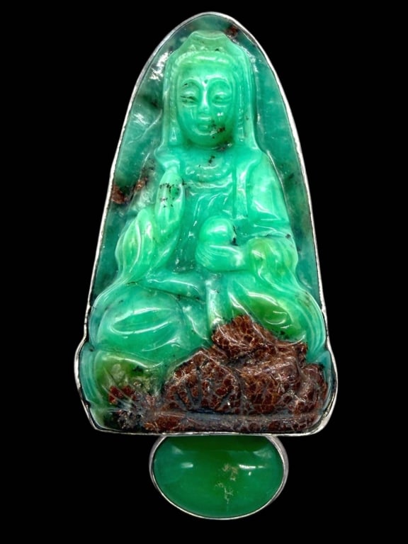 HAND-CARVED HARD STONE GUANYIN PENDANT 3": Exceptional hand-carved jade colored pendant depicting Guanyin, the Bodhisattva of Compassion, gracefully seated upon a rocky outcrop with flowing robes and serene facial features. The translucent gre