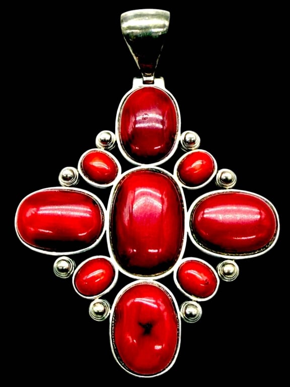 STERLING RED CORAL PENDANT 2": Sterling silver statement pendant showcasing seven vibrant red coral cabochons in graduated oval and round forms, bezel set in an elegant openwork design accented with polished sterling silver bead de