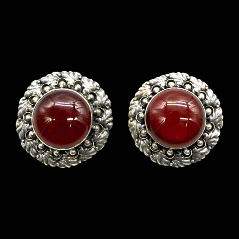 STERLING CARNELIAN CLIP-ON EARRINGS: Elegant pair of vintage sterling silver clip-on earrings featuring richly colored domed carnelian cabochons bezel set within ornate floral and beadwork surrounds. The handcrafted settings display deta