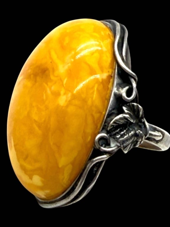 VINTAGE STERLING BUTTERSCOTCH AMBER RING SZ 6: Elegant vintage sterling silver statement ring showcasing a substantial oval butterscotch amber cabochon with rich marbled honey and golden tones. The impressive gemstone is secured within an ornate h