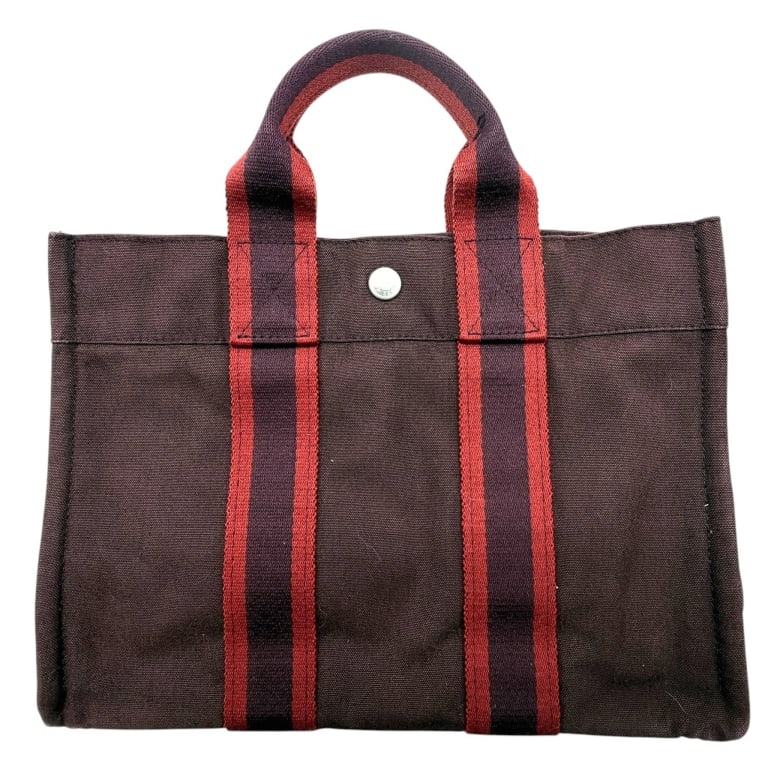 HERMES FOURRE TOUT PM TOTE 12": Classic Hermès Fourre Tout PM tote crafted in rich chocolate brown cotton canvas with signature burgundy and dark brown striped web handles. Designed for everyday sophistication, this iconic French t