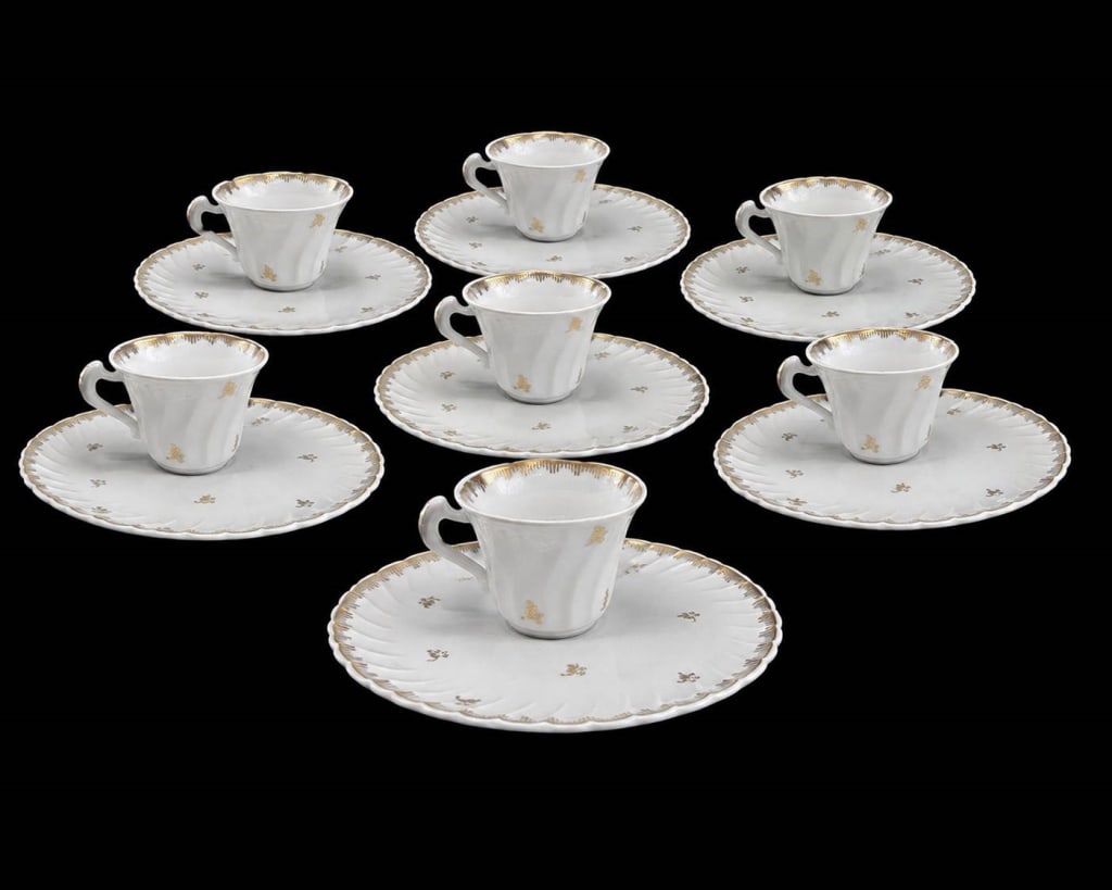 HAND PAINTED FRENCH PORCELAIN DEMITASSE SET 8PC: Delicate hand-painted French porcelain demitasse set consisting of 8 cups and 8 matching scalloped saucers. Each piece features an elegant white glazed finish accented with gilt floral sprigs and a fi