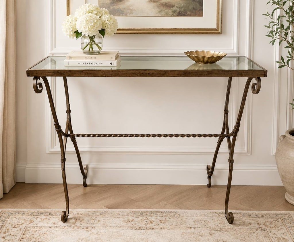 WROUGHT IRON & GLASS CONSOLE TABLE 29": An elegant wrought iron console table featuring graceful hand-forged scrollwork, slender tapered legs, and a twisted iron stretcher for added architectural interest. The rectangular clear glass top cr