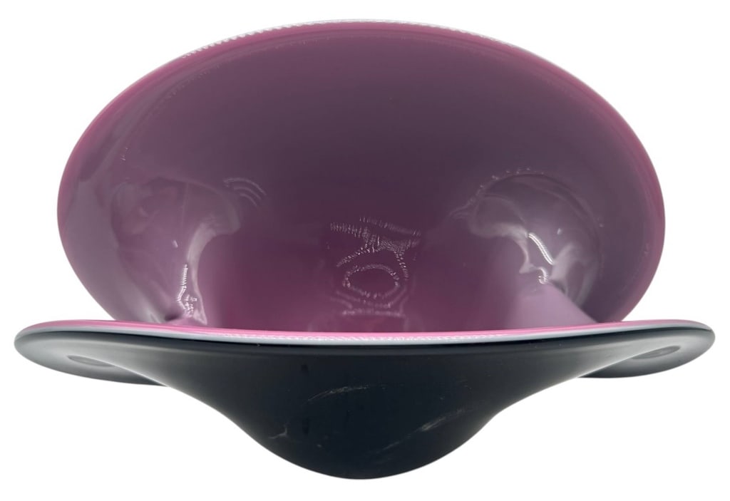 MURANO STYLE ART GLASS CENTERPIECE BOWL 12": This striking contemporary art glass centerpiece bowl features a dramatic sculptural silhouette with flowing folded rim edges. The exterior is finished in a sleek, glossy black, while the interior dis
