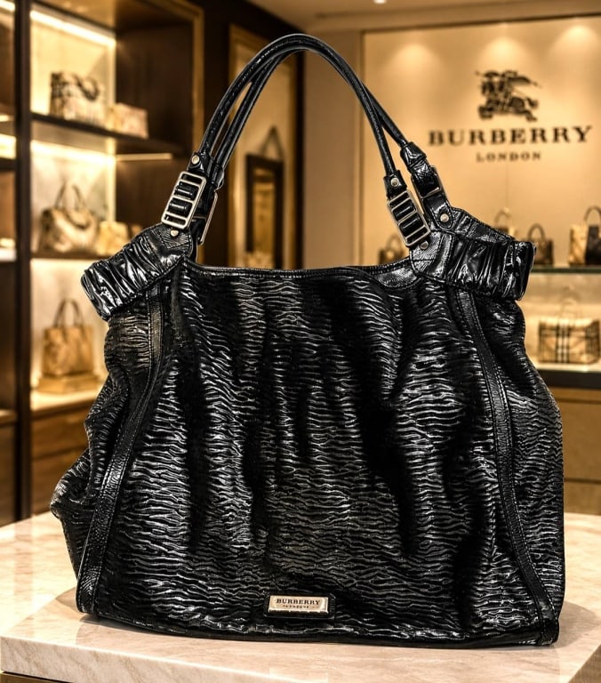 BURBERRY BLACK RIPPLE AND PATENT LEATHER TOTE 17": Burberry black patent leather shoulder tote featuring a highly textured, ripple-embossed finish with a softly structured, generously proportioned silhouette. The design is accented by gathered side pa