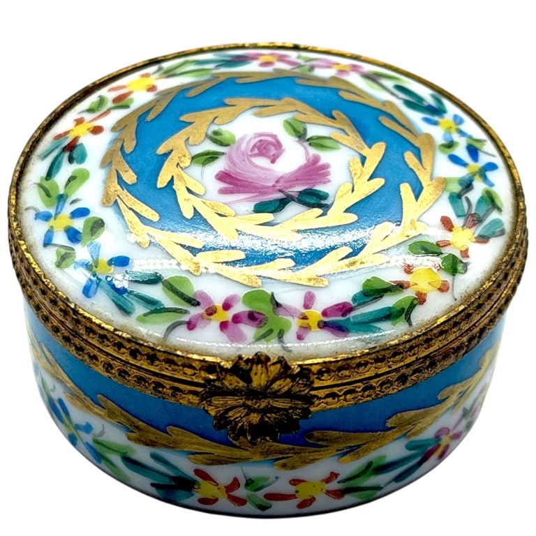 LIMOGES HAND PAINTED HAT BOX 1": Delightful miniature hand-painted Limoges porcelain trinket box featuring a central pink rose encircled by a cobalt blue medallion and gilt laurel wreath, surrounded by colorful floral sprays. The pet