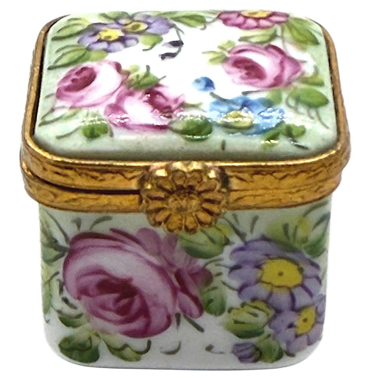 LIMOGES HAND PAINTED FLORAL BOX 1": This charming miniature hand-painted Limoges porcelain trinket box features an all-over floral design with delicate pink roses, blue blossoms, lavender flowers, and soft green foliage. The square form