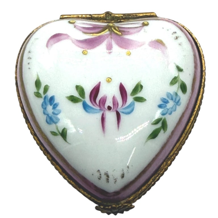 LIMOGES HEART SHAPED BOX 2": This charming heart-shaped Limoges porcelain trinket box is beautifully hand decorated with delicate pink and blue floral motifs accented by raised gilt detailing and a soft rose border. The elegant h