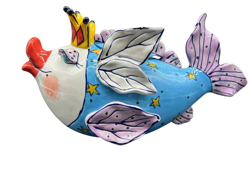 WHIMSICAL FLYING FISH CERAMIC TEAPOT: Whimsical figural ceramic teapot modeled as a fanciful flying FISH wearing a crown, with the pig's open mouth forming the spout and its tail serving as the handle. The colorful hand-painted design fea