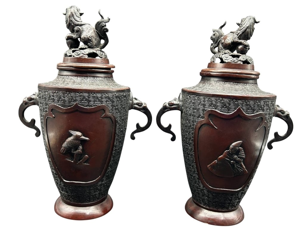 PAIR CHINESE RELIEF COVERED URNS 11: Pair of Chinese patinated metal covered urns featuring archaistic geometric decoration and contrasting reddish-brown panels. Each tapered vessel is fitted with scrolling side handles, raised bird deco