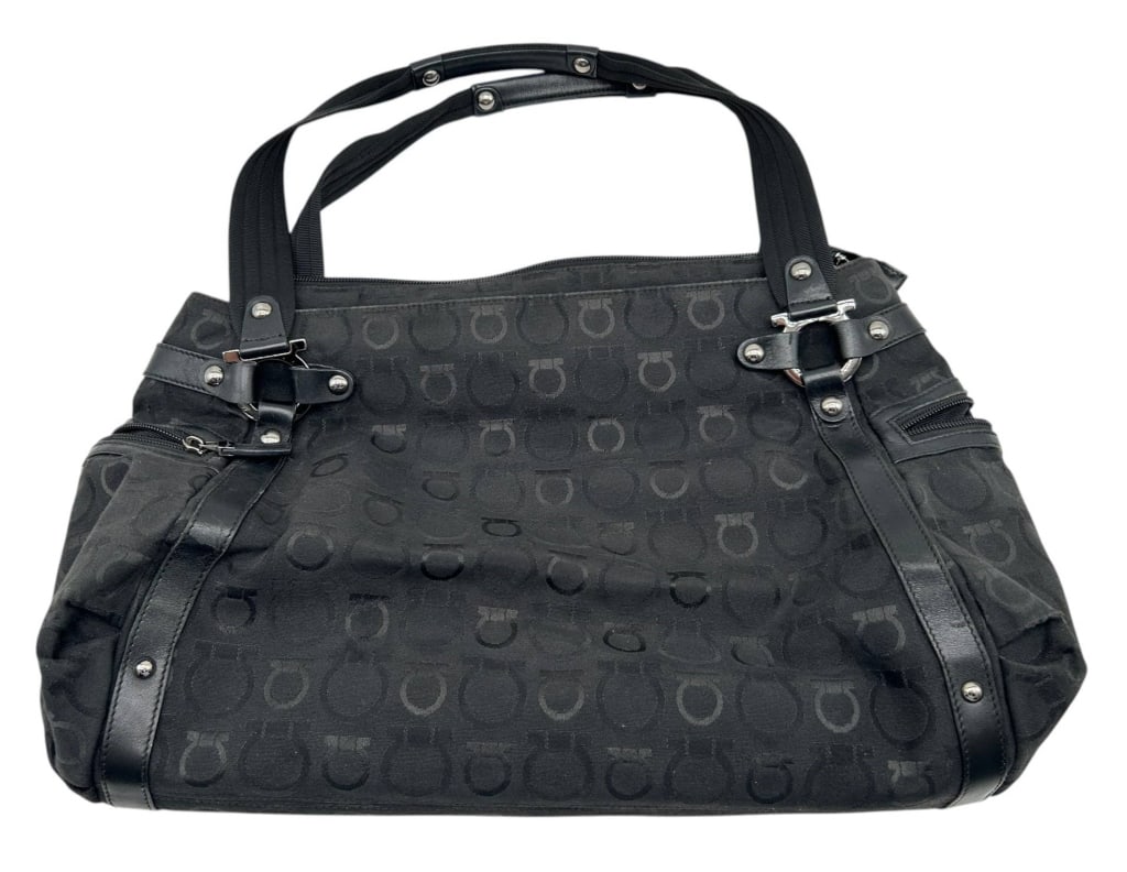 SALVATORE FERRAGAMO GANCINI TRAVEL TOTE 18": Classic Salvatore Ferragamo travel tote crafted in black Gancini jacquard canvas with smooth black leather trim and dual webbed leather handles. The bag features signature Gancini hardware accents, mu