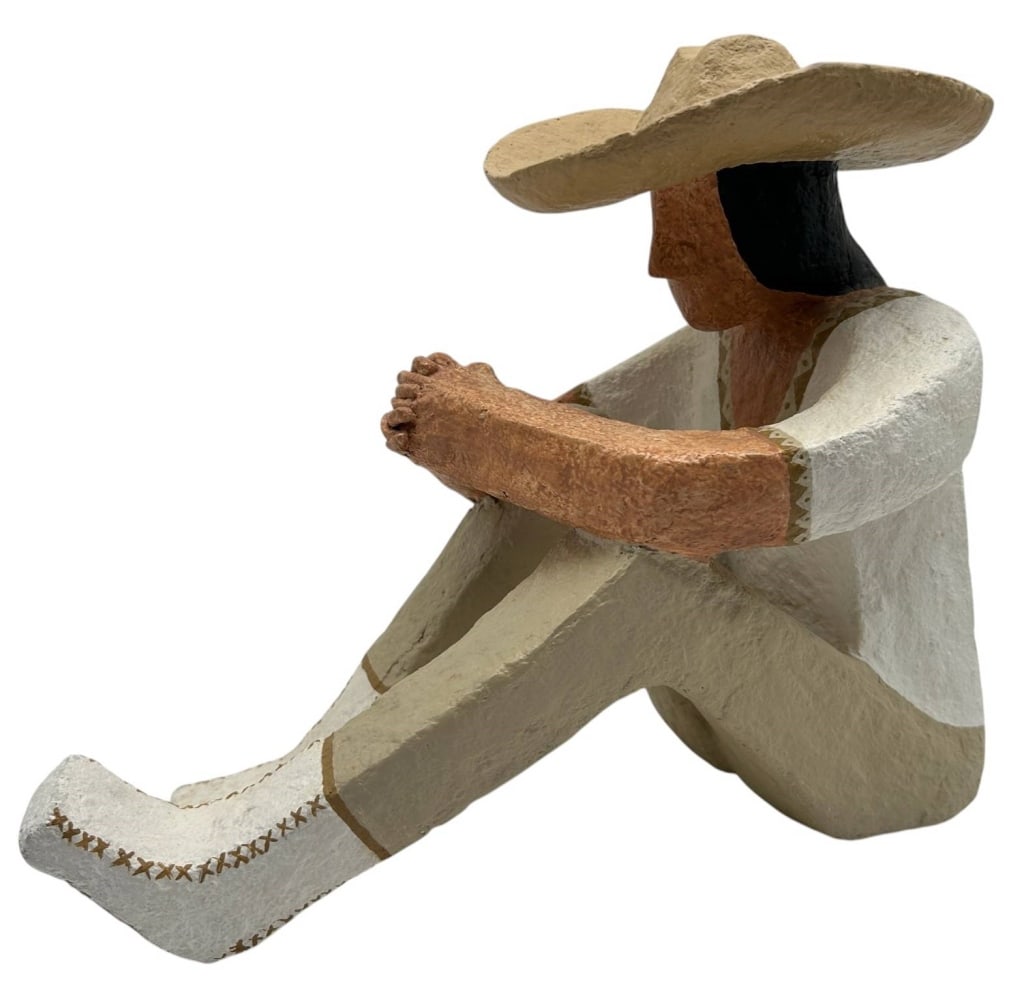 DEBRA CAMERON SEATED FIGURAL SCULPTURE 13": Contemporary hand-painted figural sculpture by Debra Cameron depicting a seated woman wearing a wide-brimmed hat with her arms resting across her knees. Executed in a stylized folk art aesthetic with 
